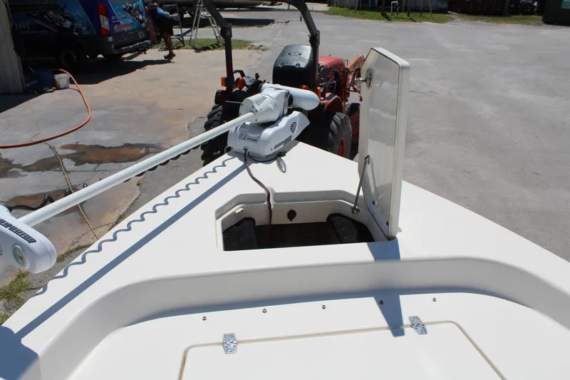 Slide: The Image of 2015 Pathfinder 2200 boat with trolling motor and open hatch, parked near a tractor. - 21