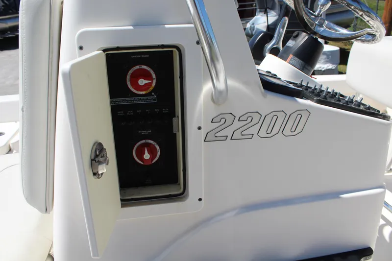 Slide: The Image of 2015 Pathfinder 2200 boat console with open electrical panel and steering wheel. - 22