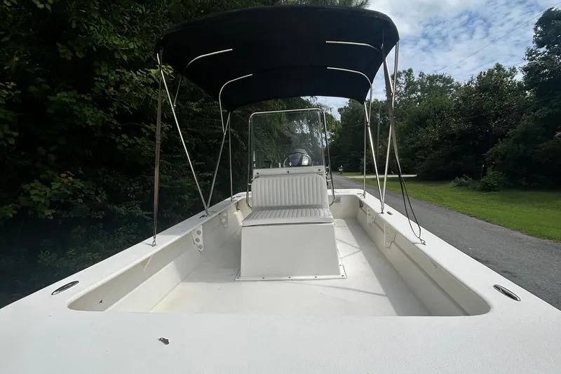 Slide: The Image of 2010 Southern Skimmer 19SS boat with canopy, parked on a tree-lined road. - 4