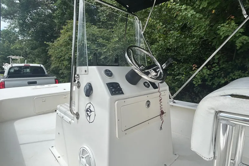 Slide: The Image of 2010 Southern Skimmer 19SS boat console with steering wheel, parked near trees. - 5