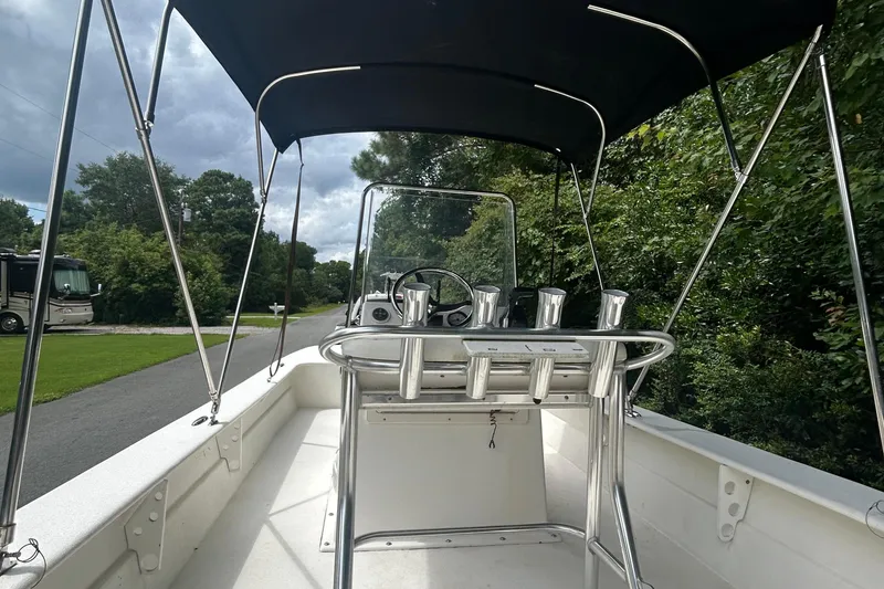 Slide: The Image of 2010 Southern Skimmer 19SS boat with canopy, steering console, and rod holders on a scenic road. - 9