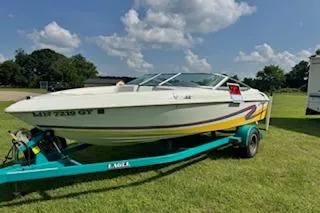 Slide: The Image of 1996 Baja 188 Islander boat on trailer, parked on grass under a clear blue sky. - 0
