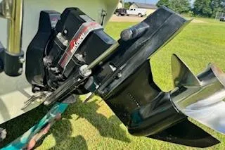 Slide: The Image of 1996 Baja 188 Islander boat on trailer, parked on grassy field under cloudy sky. - 4