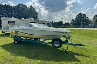 Slide: The Image of 1996 Baja 188 Islander 25th Anniversary boat on trailer, parked on grass. - 7