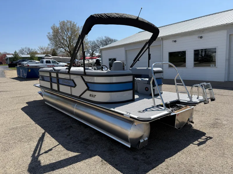 Slide: The Image of 2025 Bentley Pontoons Bolt 223 pontoon boat with canopy, parked outdoors near a building. - 5