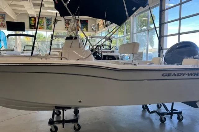 Slide: The Image of 2023 Grady White Fisherman 180 boat displayed in a showroom with modern decor. - 2