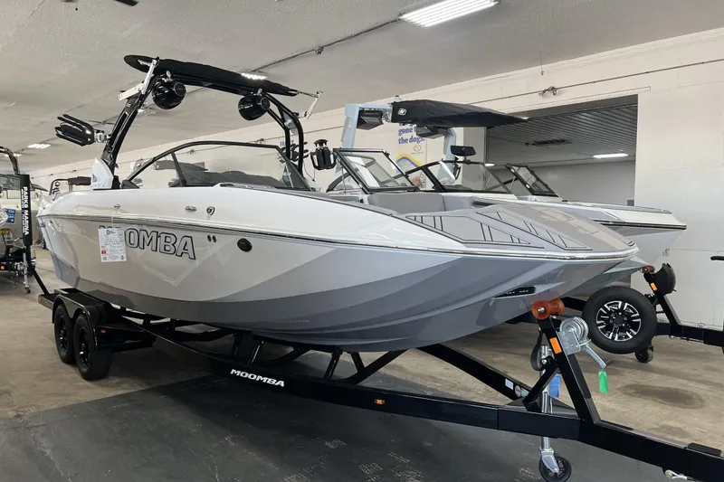 Slide: The Image of 2023 Moomba Makai boat on trailer in showroom, featuring sleek design and modern features. - 1