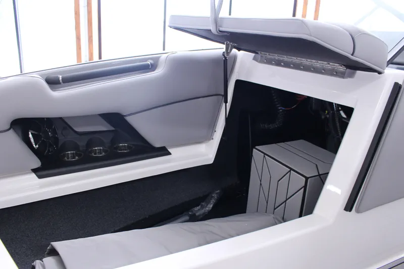 Slide: The Image of 2023 Moomba Makai boat interior storage compartment with open seat and cup holders. - 21