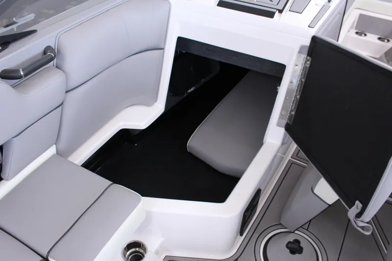 Slide: The Image of 2023 Moomba Makai boat interior with open storage compartment and gray seating. - 22