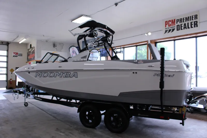 Slide: The Image of 2023 Moomba Makai boat in showroom, side view, on trailer, PCM Premier Dealer sign. - 29