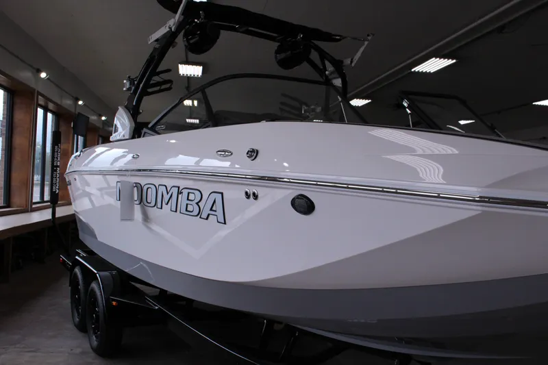 Slide: The Image of 2023 Moomba Makai boat in showroom, sleek white design on trailer. - 4