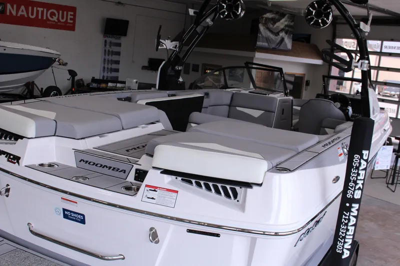Slide: The Image of 2023 Moomba Makai boat interior with spacious seating and sleek design in showroom. - 8