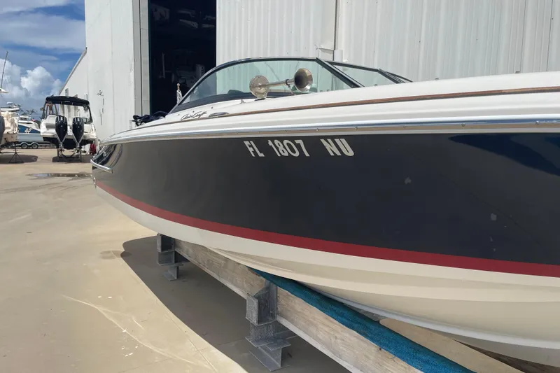 Slide: The Image of 2008 Chris-Craft Launch 25 boat on dry dock, navy hull with red stripe. - 1