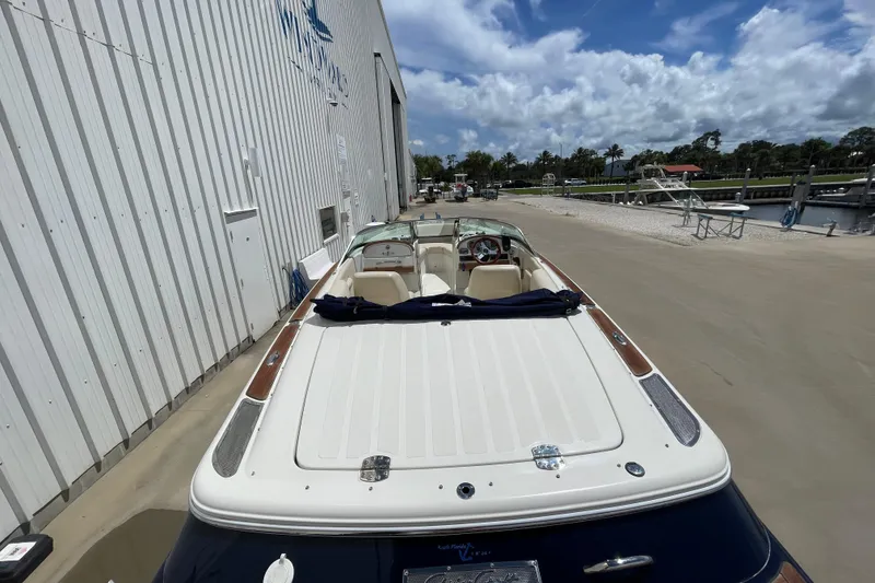 Slide: The Image of 2008 Chris-Craft Launch 25 boat docked near a marina under a partly cloudy sky. - 10