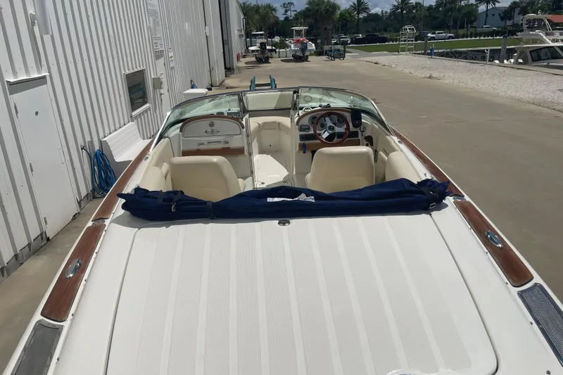 Slide: The Image of 2008 Chris-Craft Launch 25 boat with elegant interior and wooden accents, docked outdoors. - 5