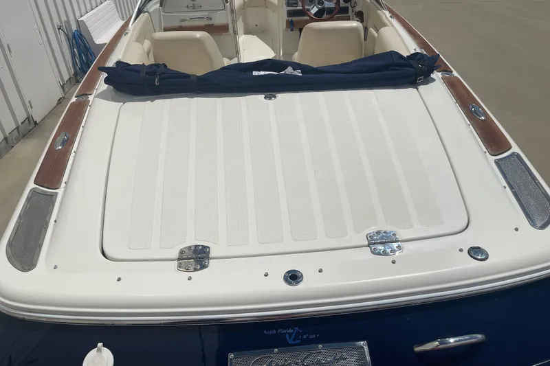 Slide: The Image of 2008 Chris-Craft Launch 25 boat with white and wood accents, docked outdoors. - 9