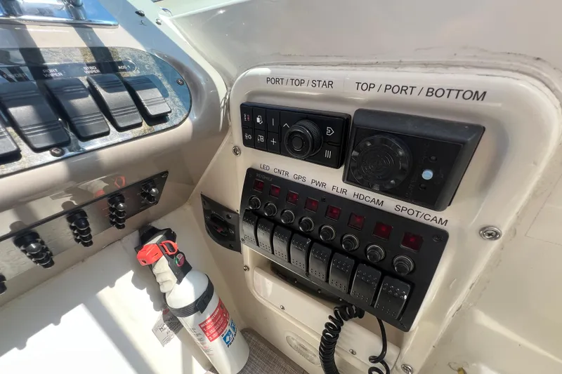 Slide: The Image of Control panel of a 2001 Cruisers Yachts 3672 Express with various switches and a fire extinguisher. - 13