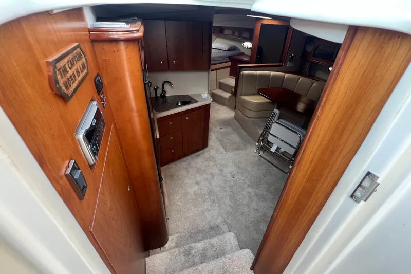 Slide: The Image of Interior of 2001 Cruisers Yachts 3672 Express, featuring cozy cabin and kitchenette. - 18