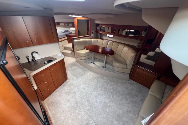 Slide: The Image of 2001 Cruisers Yachts 3672 Express interior with kitchenette, seating area, and cozy cabin. - 19