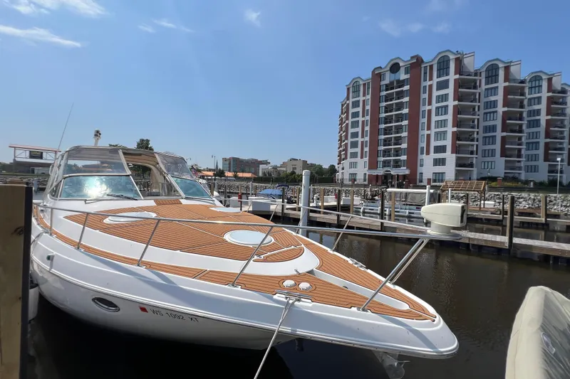 Slide: The Image of 2001 Cruisers Yachts 3672 Express docked near waterfront buildings under clear sky. - 2