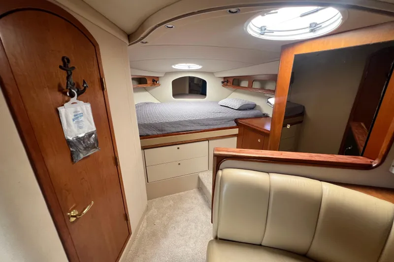 Slide: The Image of 2001 Cruisers Yachts 3672 Express cabin interior with bed, wood accents, and seating area. - 25