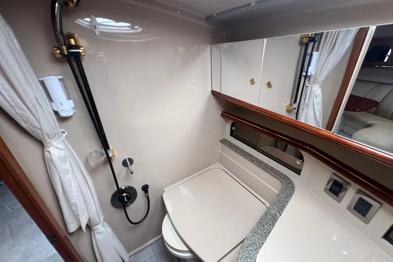 Slide: The Image of 2001 Cruisers Yachts 3672 Express bathroom with shower, mirror, and storage cabinets. - 29