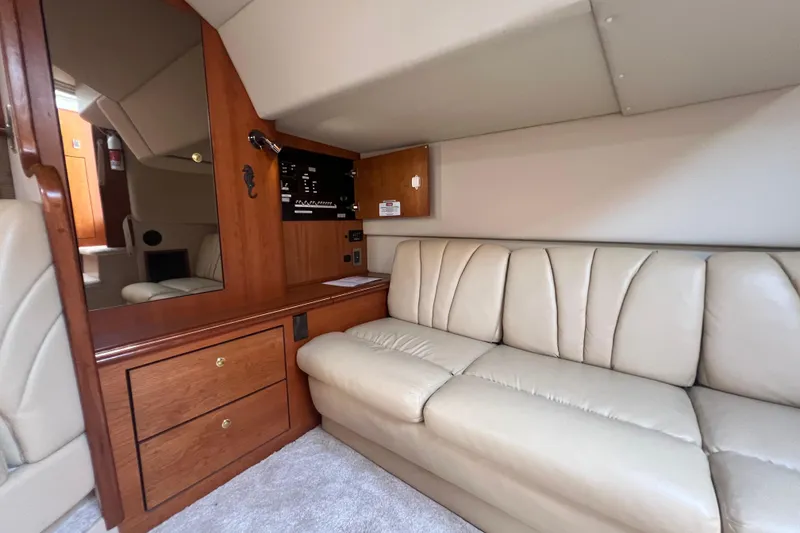 Slide: The Image of 2001 Cruisers Yachts 3672 Express interior with beige leather sofa and wooden cabinetry. - 30