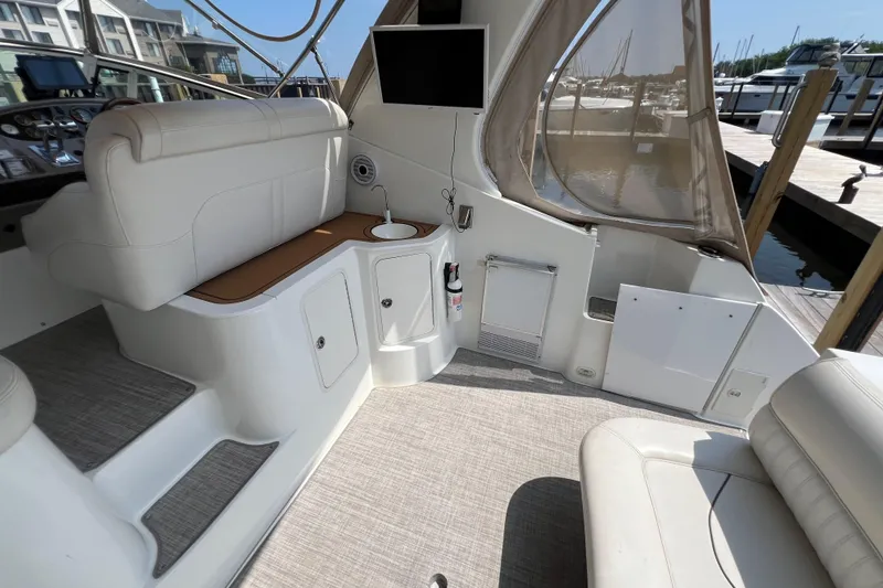 Slide: The Image of 2001 Cruisers Yachts 3672 Express interior with seating, TV, and marina view. - 6