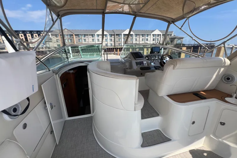 Slide: The Image of 2001 Cruisers Yachts 3672 Express cockpit with helm, seating, and marina view. - 8