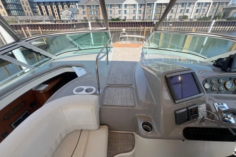 Slide: The Image of 2001 Cruisers Yachts 3672 Express cockpit with helm, seating, and waterfront view. - 14