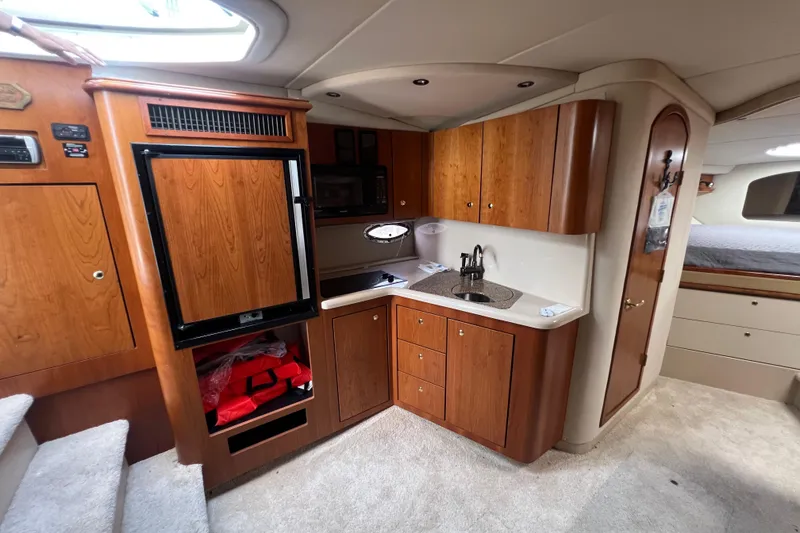 Slide: The Image of 2001 Cruisers Yachts 3672 Express interior with kitchenette and wood cabinetry. - 21