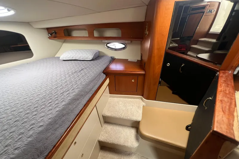Slide: The Image of 2001 Cruisers Yachts 3672 Express cabin interior with bed, wooden cabinetry, and steps. - 26