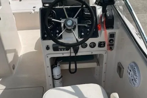 Slide: The Image of 1996 Scout 202 Dorado boat cockpit with steering wheel and control panel. - 10