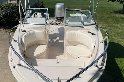 Slide: The Image of 1996 Scout 202 Dorado boat with dual seating and outboard motor, docked on grass. - 12