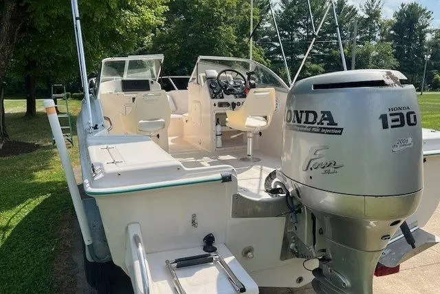 Slide: The Image of 1996 Scout 202 Dorado boat with Honda 130 outboard motor, parked on grass. - 6