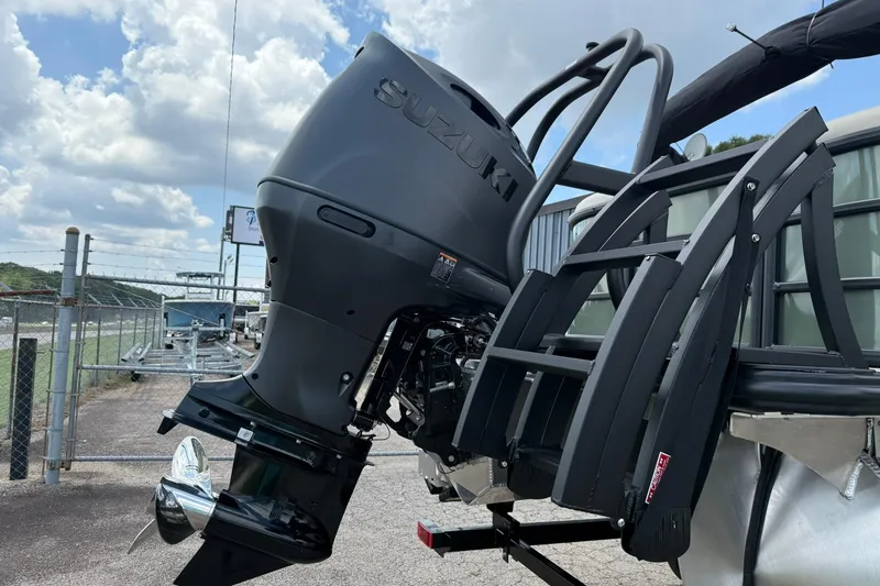 Slide: The Image of 2026 Bentley Pontoons Legacy 243 Navigator with Suzuki outboard motor, parked outdoors. - 12