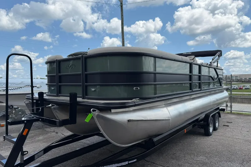 Slide: The Image of 2026 Bentley Pontoons Legacy 243 Navigator on trailer under a cloudy sky. - 2