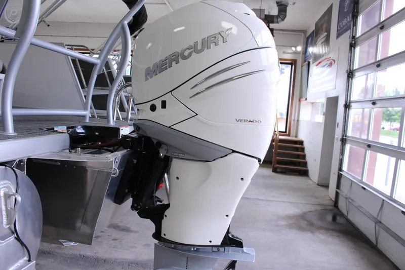 Slide: The Image of 2023 Premier 250 Intrigue with Mercury Verado outboard motor in a garage setting. - 10
