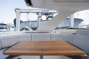 Slide: The Image of 2023 Sea Ray SLX 350 Outboard interior with elegant wooden table and seating. - 14