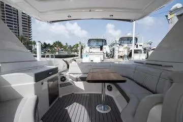 Slide: The Image of 2023 Sea Ray SLX 350 Outboard interior with seating and table, docked at marina. - 16