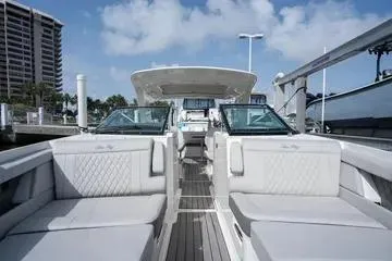 Slide: The Image of 2023 Sea Ray SLX 350 Outboard luxury boat interior with plush seating at a marina. - 21
