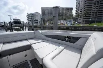 Slide: The Image of 2023 Sea Ray SLX 350 Outboard luxury boat interior with plush seating at marina. - 22