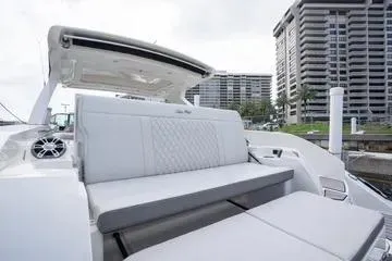 Slide: The Image of 2023 Sea Ray SLX 350 Outboard boat with luxurious seating, docked near modern buildings. - 24