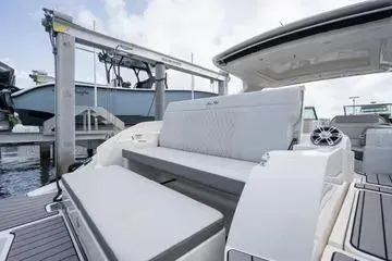Slide: The Image of 2023 Sea Ray SLX 350 Outboard luxury seating area at a marina. - 25