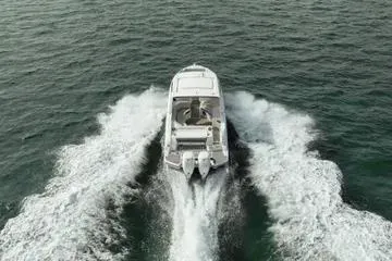 Slide: The Image of 2023 Sea Ray SLX 350 Outboard cruising on open water, rear view. - 7