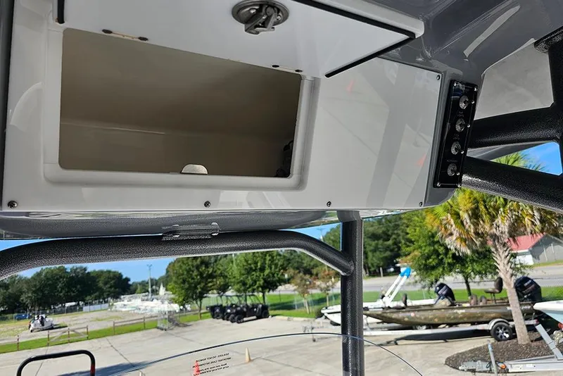 Slide: The Image of 2025 Sea Pro 222 Center Console boat storage compartment, open with visible controls. - 24
