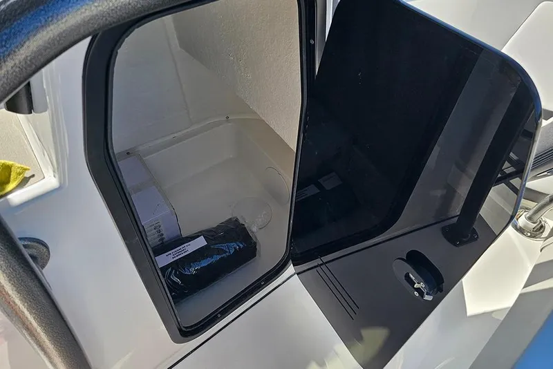 Slide: The Image of 2025 Sea Pro 222 Center Console storage compartment with open door, showcasing interior space. - 26