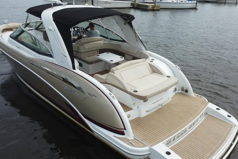 Slide: The Image of 2013 Formula 350 CBR boat with beige seating, black canopy, docked on calm water. - 15