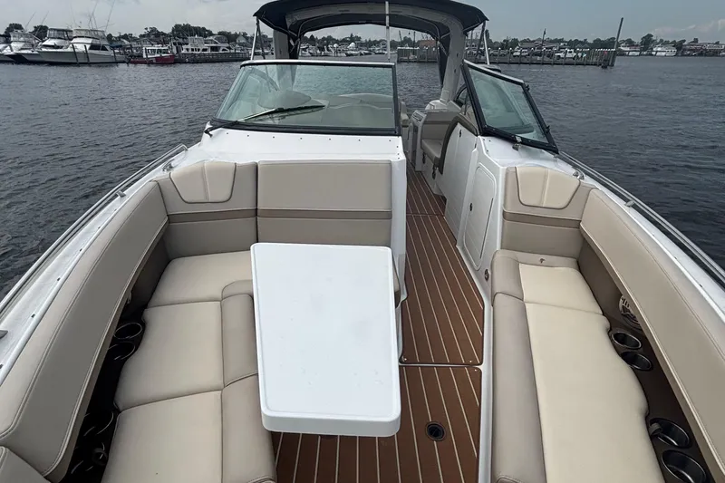 Slide: The Image of 2013 Formula 350 CBR boat interior with beige seating and white table on the water. - 35