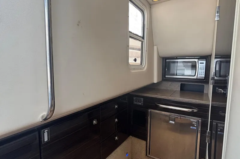 Slide: The Image of Interior of 2013 Formula 350 CBR boat featuring a compact kitchen area with microwave. - 41